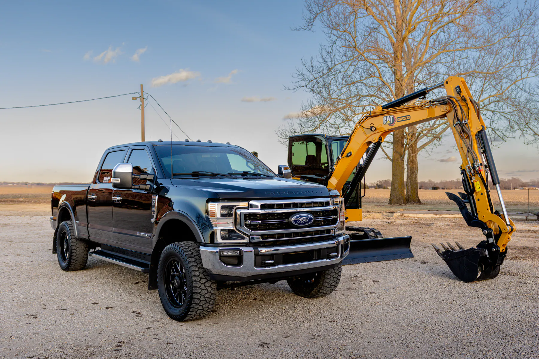 Detailed black Ford truck parked beside a yellow excavator